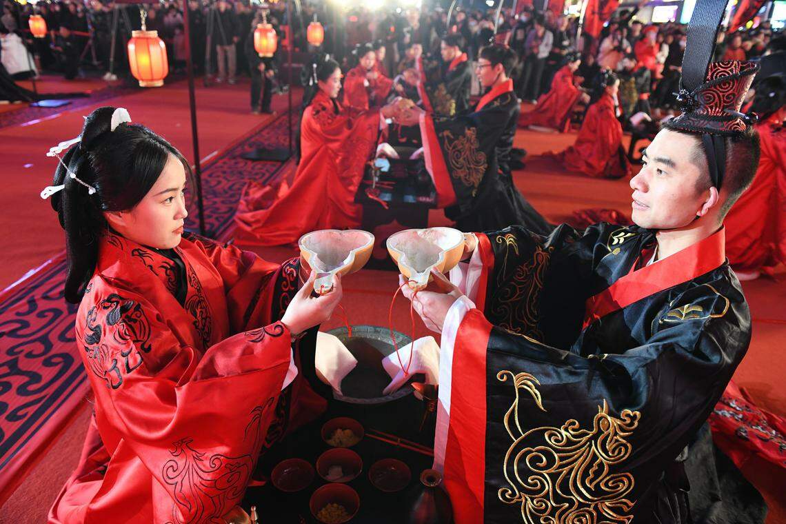 一些地方由政府主导,定期举办联谊交友、集体婚礼等活动,助力年轻人步入婚姻。图为12月2日在湖南长沙举行的汉式集体婚礼上,身穿汉服的新人行合卺礼。(中新社)