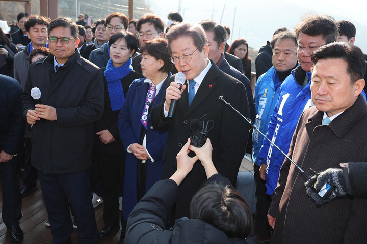 李在明1月2日在釜山视察加德岛新机场选址,之后接受媒体访问时遇袭。(路透社)