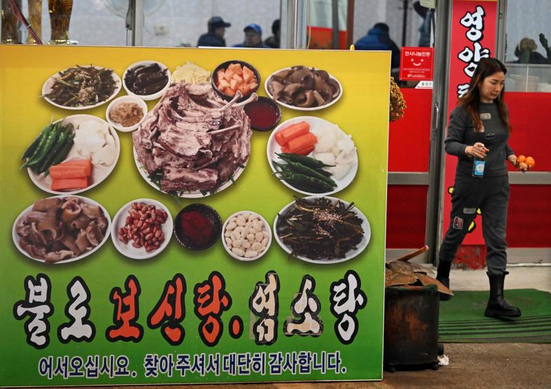 韩国年轻人大多早已不吃狗肉,只是年长者仍在坚持这项传统,或以此为生。图为大邱一家餐馆外展示店里售卖的狗肉汤。(法新社)