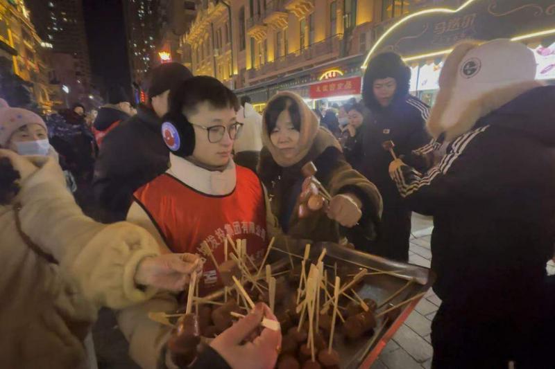 哈尔滨市民对游客的热情款待在社交媒体被放大,使各地网民心生向往。图为有哈尔滨企业在中央大街免费为游客提供红肠。(林煇智摄)