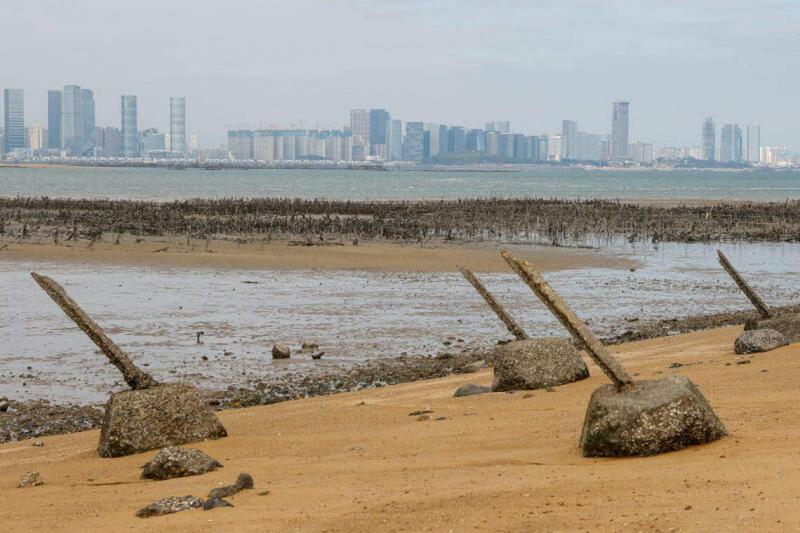 遥望厦门城市风景线的台湾金门岛,海滩上布满防御桩。(路透社)