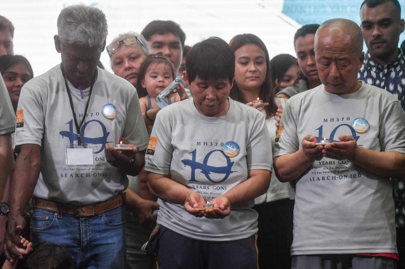 乘客家属手捧烛火,缅怀在MH370事件中逝去的家人。(法新社)