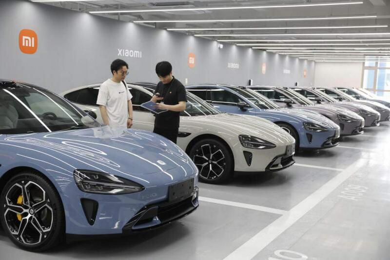 4月3日,在小米汽车交付中心(上海九淦店),工作人员为首批小米SU7汽车用户填写相关交付信息。(中新社)