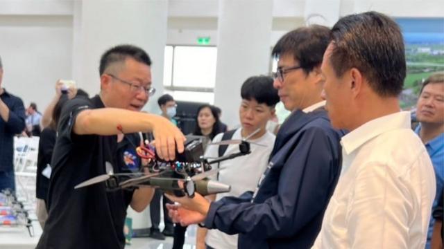 雷虎科技总经理苏圣杰(图左)向嘉义县长翁章梁(图右)及高雄市长陈其迈(图中)介绍自杀攻击无人机