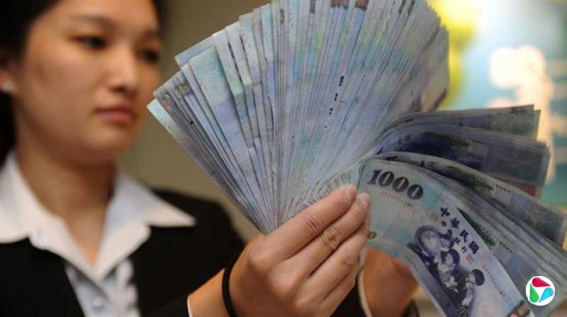 一名女士正在数新台币钞票。