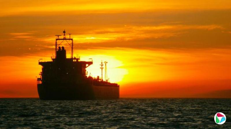 一艘货轮在海上,背景是日落时的夕阳。
