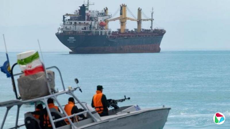 һ��С��Ѳ��ͧ��ƽ������ɫˮ���ϼ��ۣ�ͧ�����ż�����������ɫ�����µ��ˡ�������һ��ͧ��װ�л�ǹ����ͧβƮ����һ�����ʹ��졣Զ����һ�Ҿ޴�ĺ�ɫ��ֻ���ص�ͣ����ˮ�У��װ��ϼ��ż�̨��ɫ���ػ���