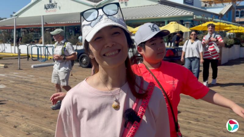 ǳ������վ�ڻ������룬����һ������ñ��ñ���Ϸ�����һ���۾������Ķ���վ�������󣬴��ź�ɫ���¡�����վ��һ��ľ�Ʋ����ϣ�������һ�Һ��ʲ�����