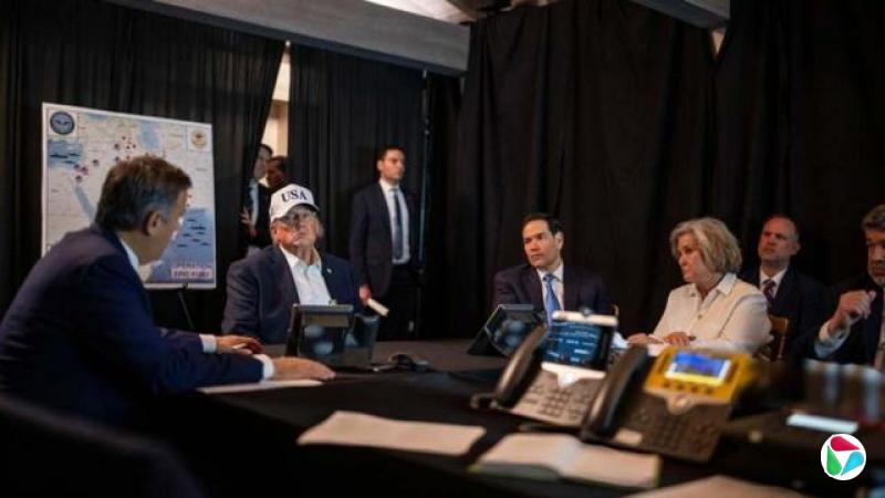 美国总统特朗普戴着一顶白色写上“USA”的帽,坐着聆听中央情报局局长约翰·拉特克利夫(John Ratcliffe)的讲话,同桌者包括美国国务卿马可·卢比奥(Marco Rubio)和白宫幕僚长苏西·威尔斯(Susie Wiles)。