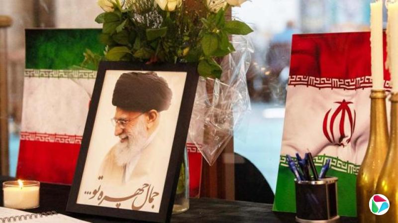 在南非开普敦的一座清真寺里,并排摆放着伊朗最高领袖阿亚图拉·阿里·哈梅内伊的画像与伊朗国旗、蜡烛和弔唁簿。