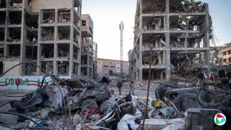 伊朗德黑兰某处居民视察美以联合空袭后的破坏情况,绘上了伊朗国旗图案的围墙附近断壁颓垣(9/3/2026)